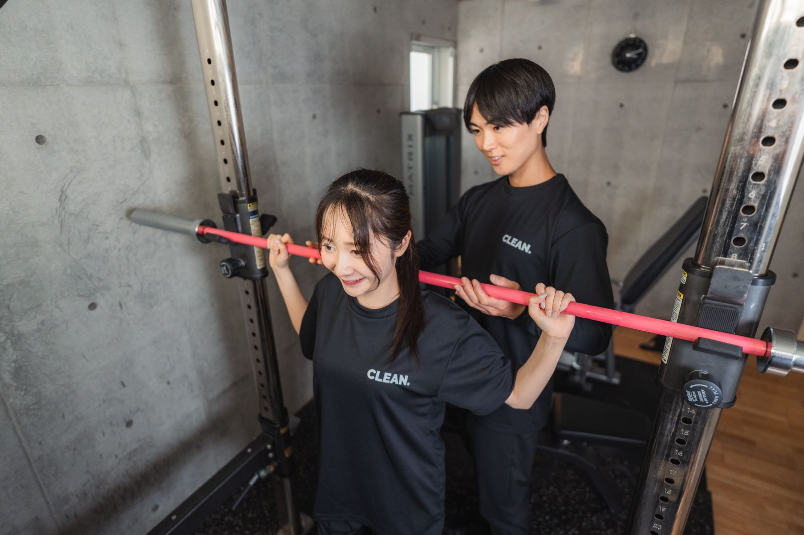 スクワットのフォームをトレーナーが確認する様子